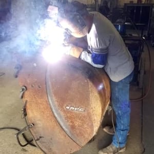 Hard at work welding a piece of industrial metal